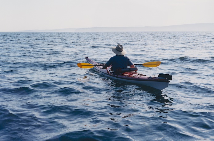 man kayaking on puget sound maritime inn gig harbor